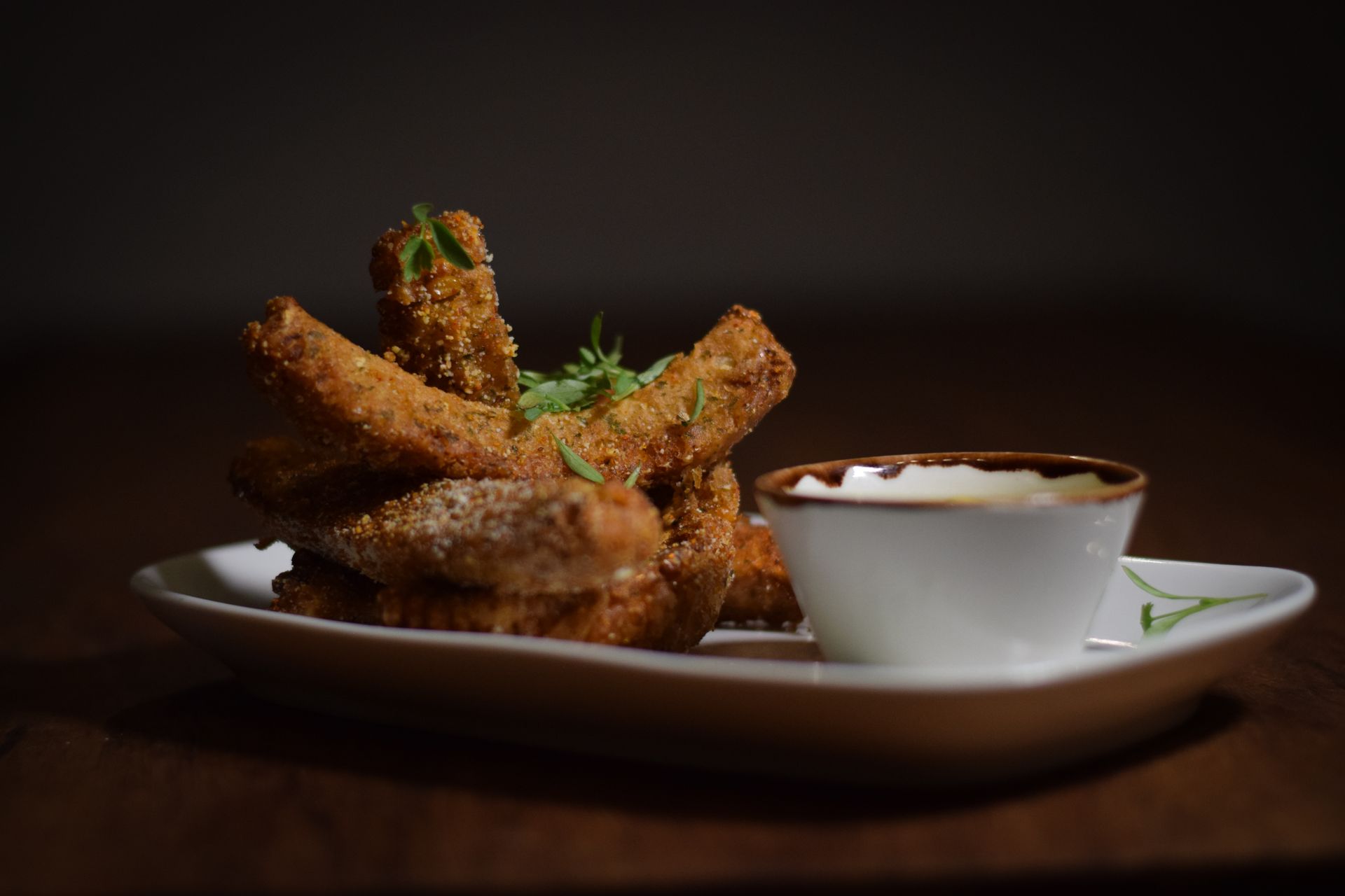 A plate of food with a bowl of dipping sauce on a table.