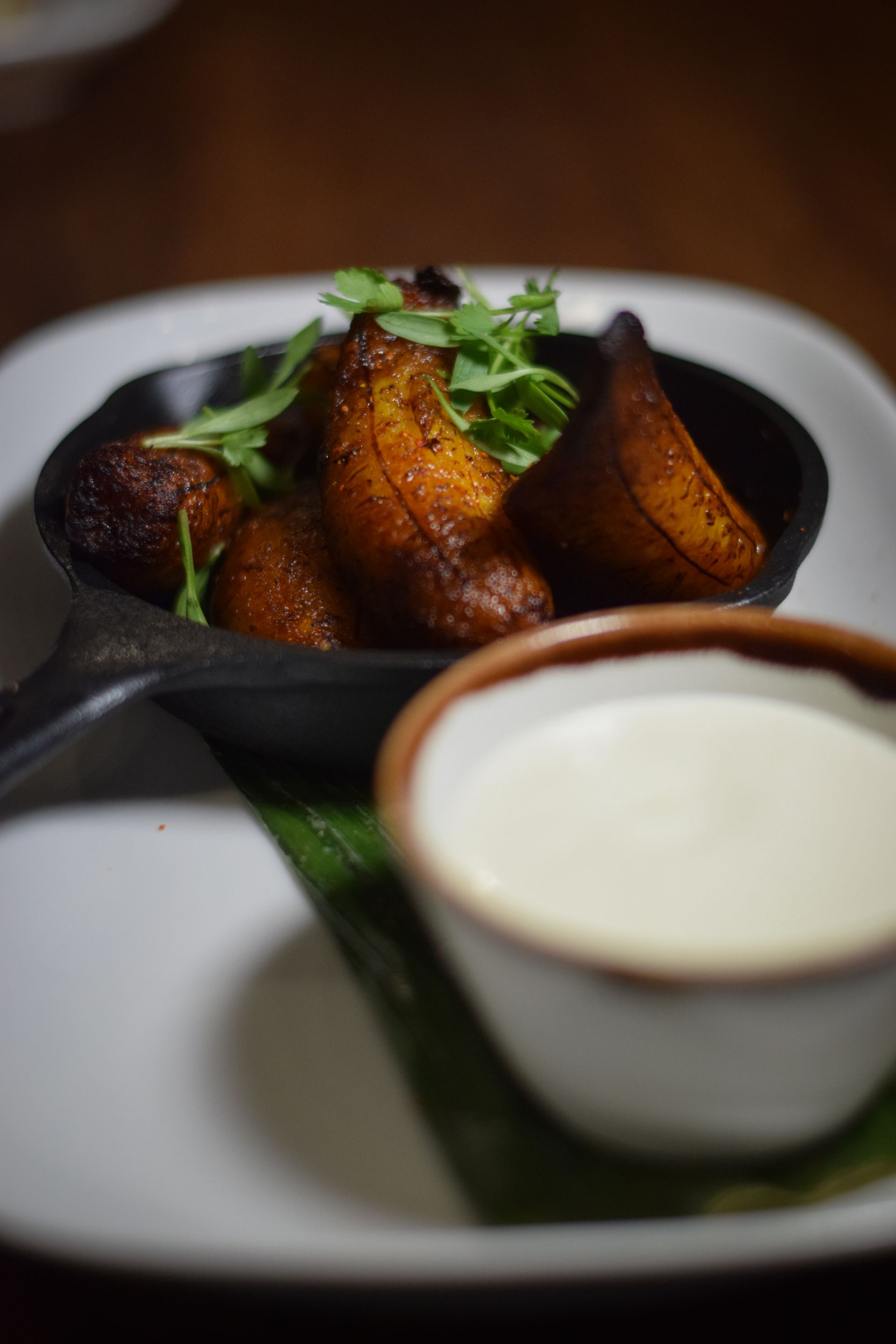 A plate of food with a bowl of sauce on a table.