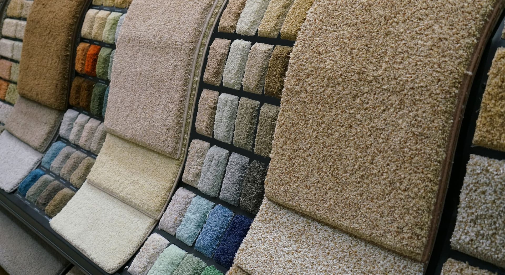 Carpet samples in various colors and textures displayed on a rack.