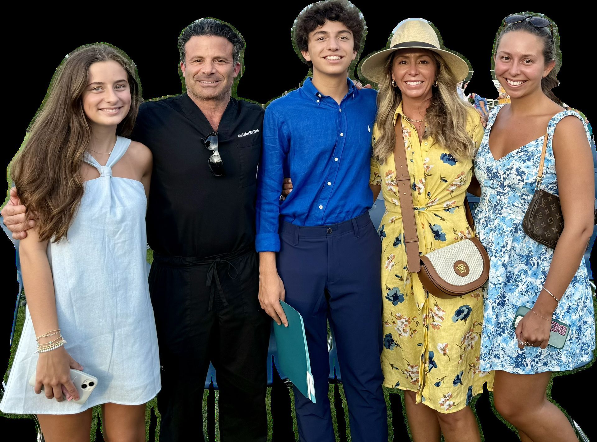 A group of people posing for a picture with one wearing a hat