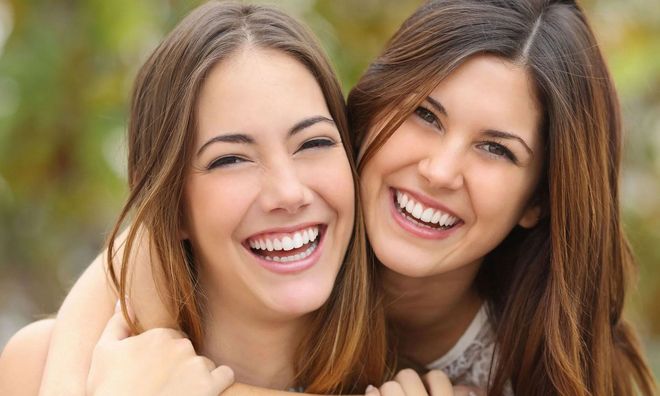Two women are hugging each other and smiling for the camera.