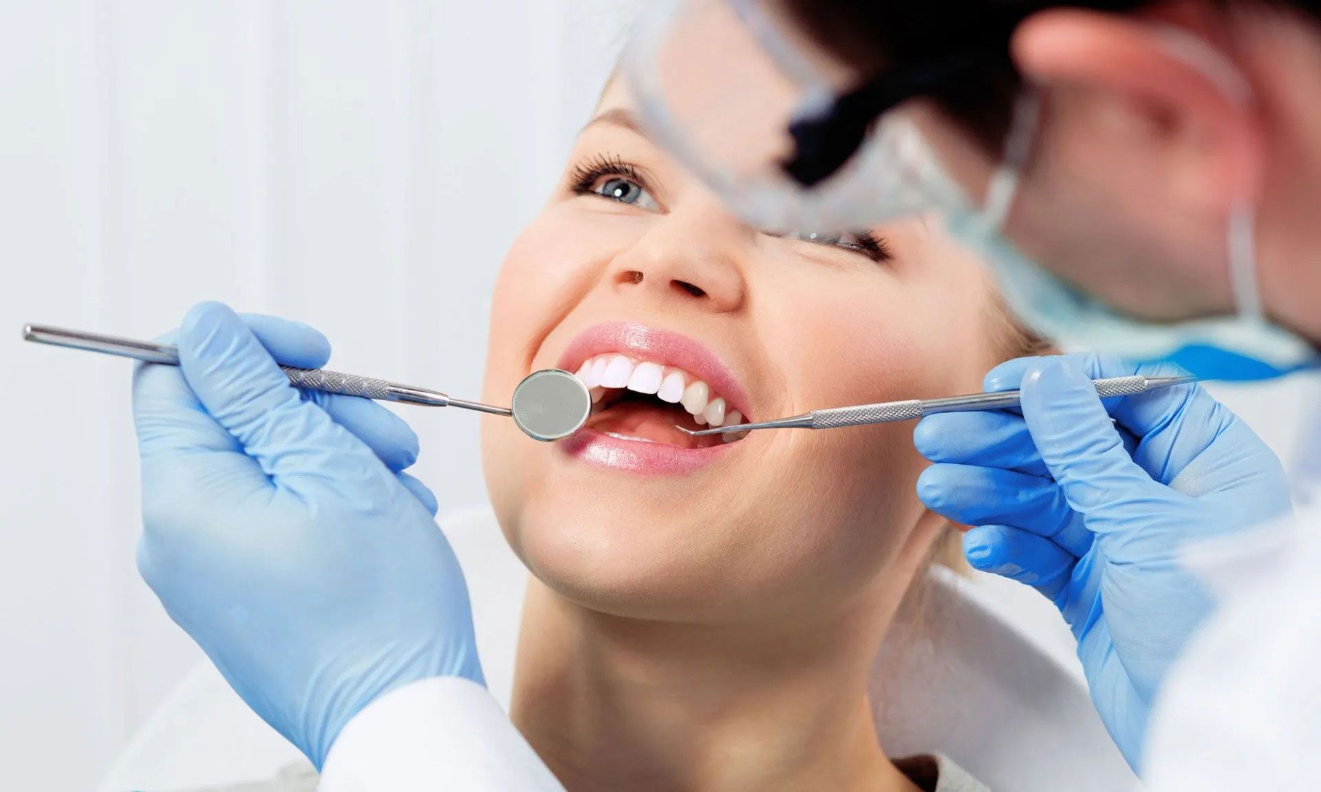 A woman is getting her teeth examined by a dentist.