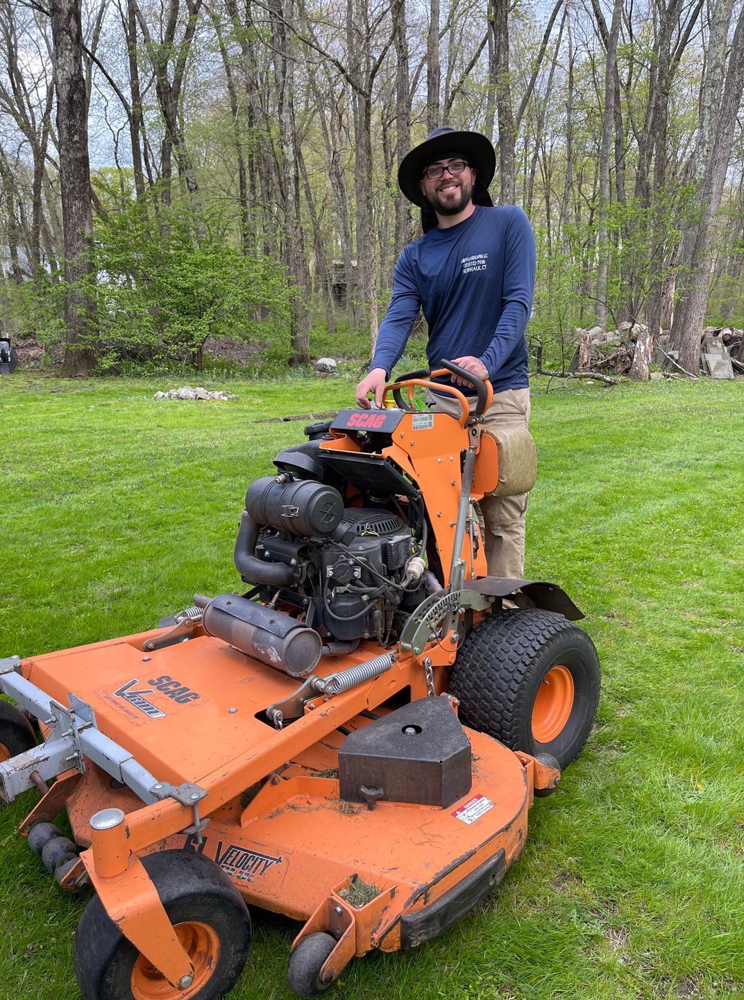 A man is riding a lawn mower on a lush green lawn.
