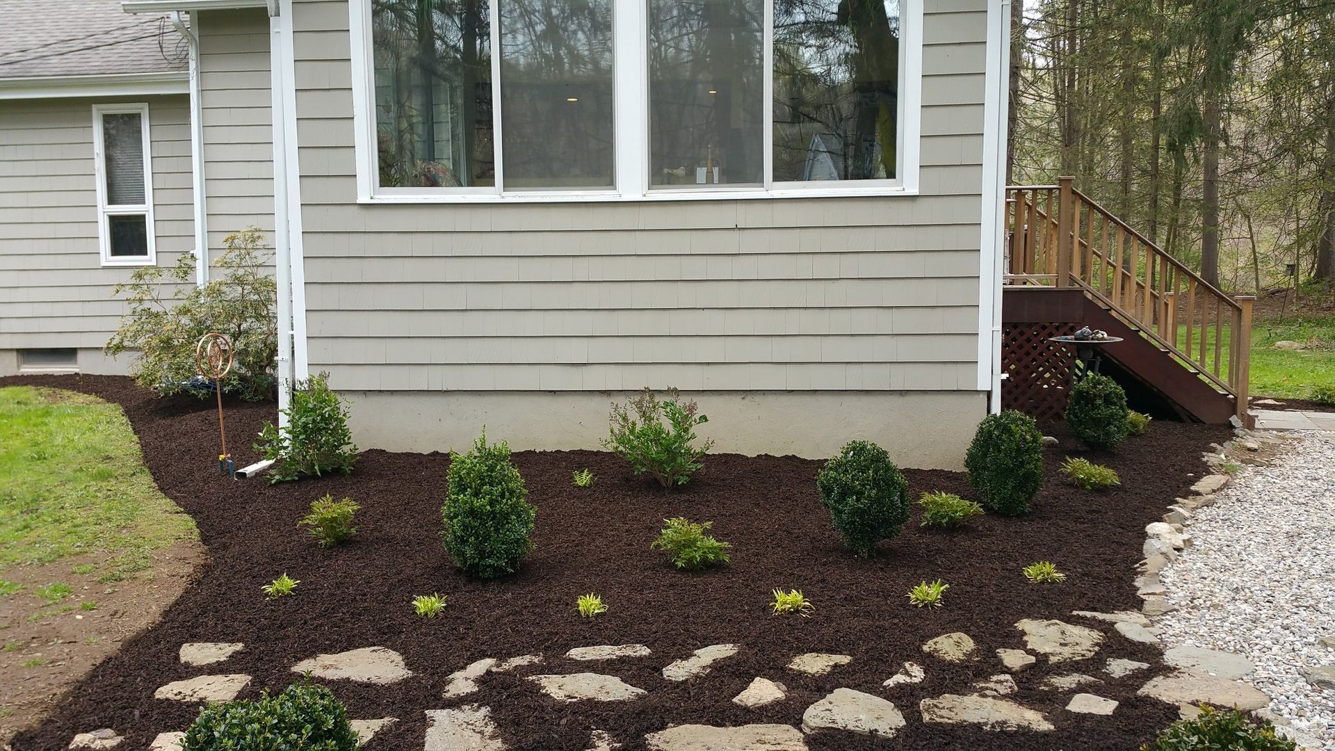 A house with a lot of plants in front of it.