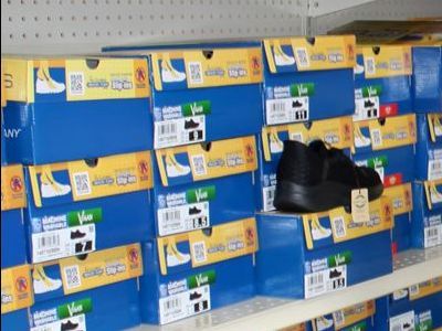 A shelf filled with lots of boxes of shoes.