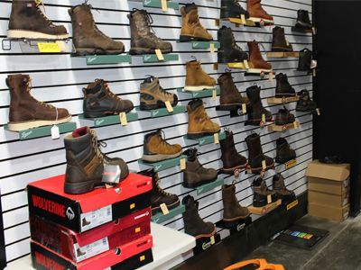 A display of boots in a store with a box that says wolverine on it