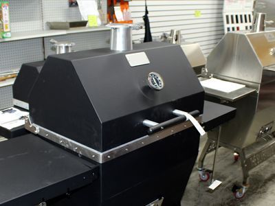 A black grill with a clock on top of it