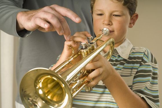 Young boy learning how to play the trumpet