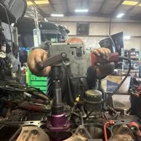 A man is working on a machine in a garage.