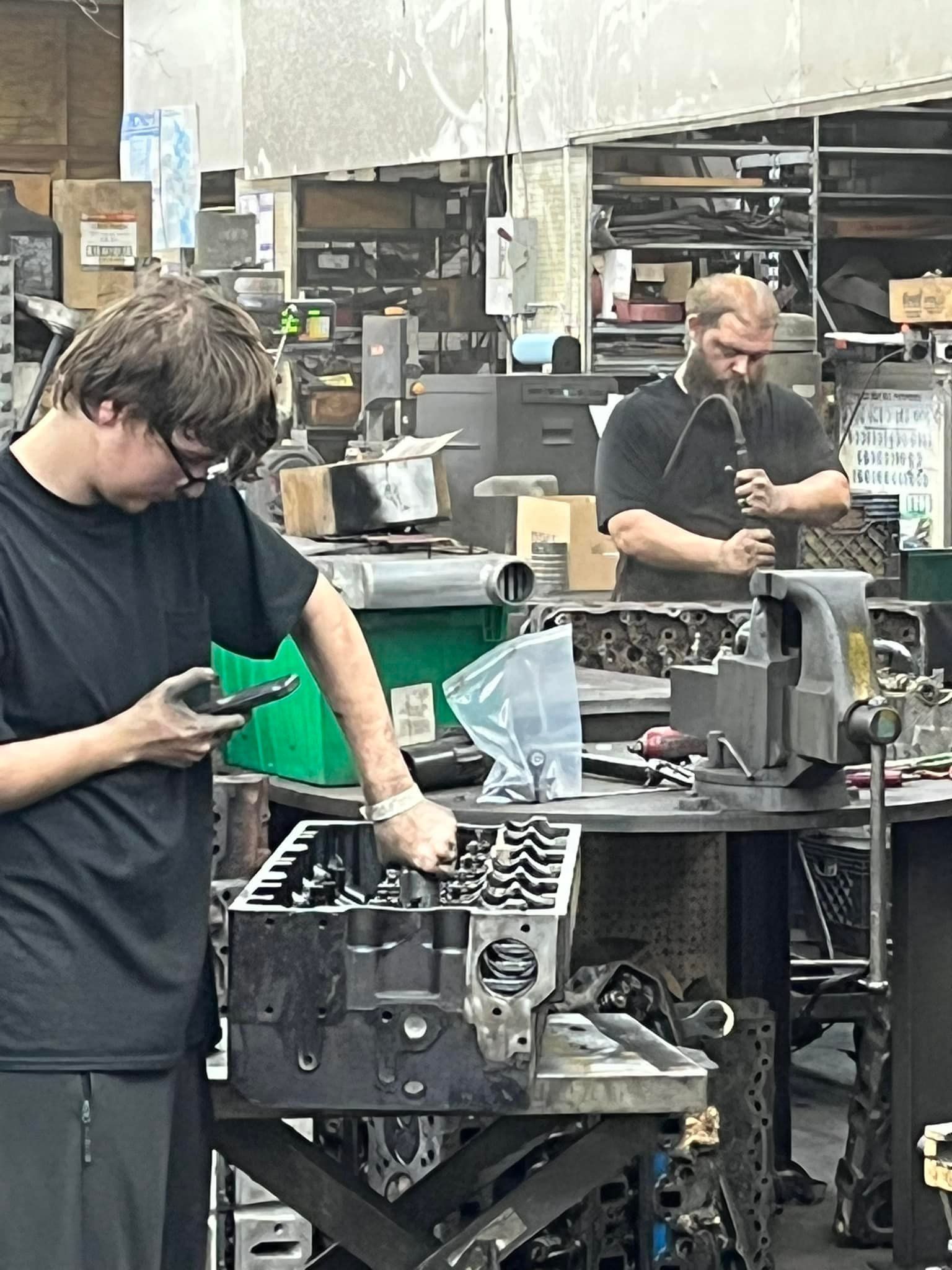 Two men are working on a machine in a factory.