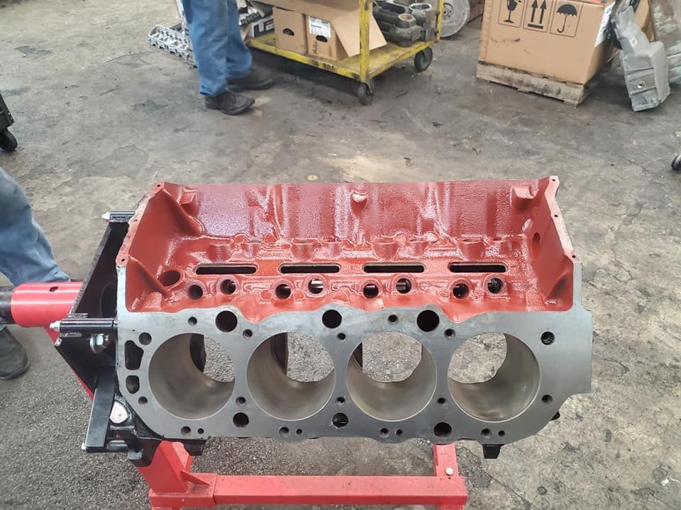 A red engine block is sitting on a red stand