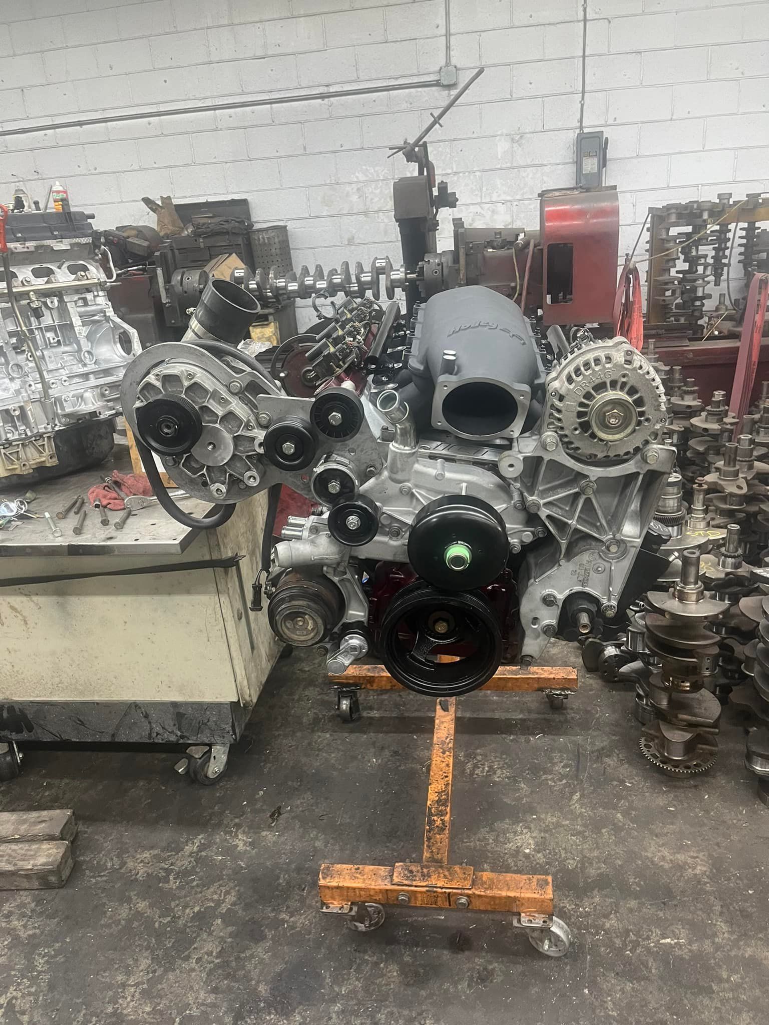 A large engine is sitting on a stand in a garage.
