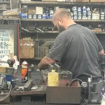 A man is working on a machine in a garage.