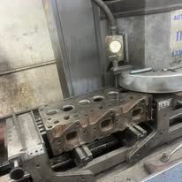A cylinder head is sitting on top of a machine.
