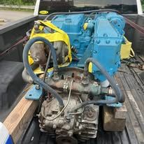 A blue engine is sitting in the back of a truck.