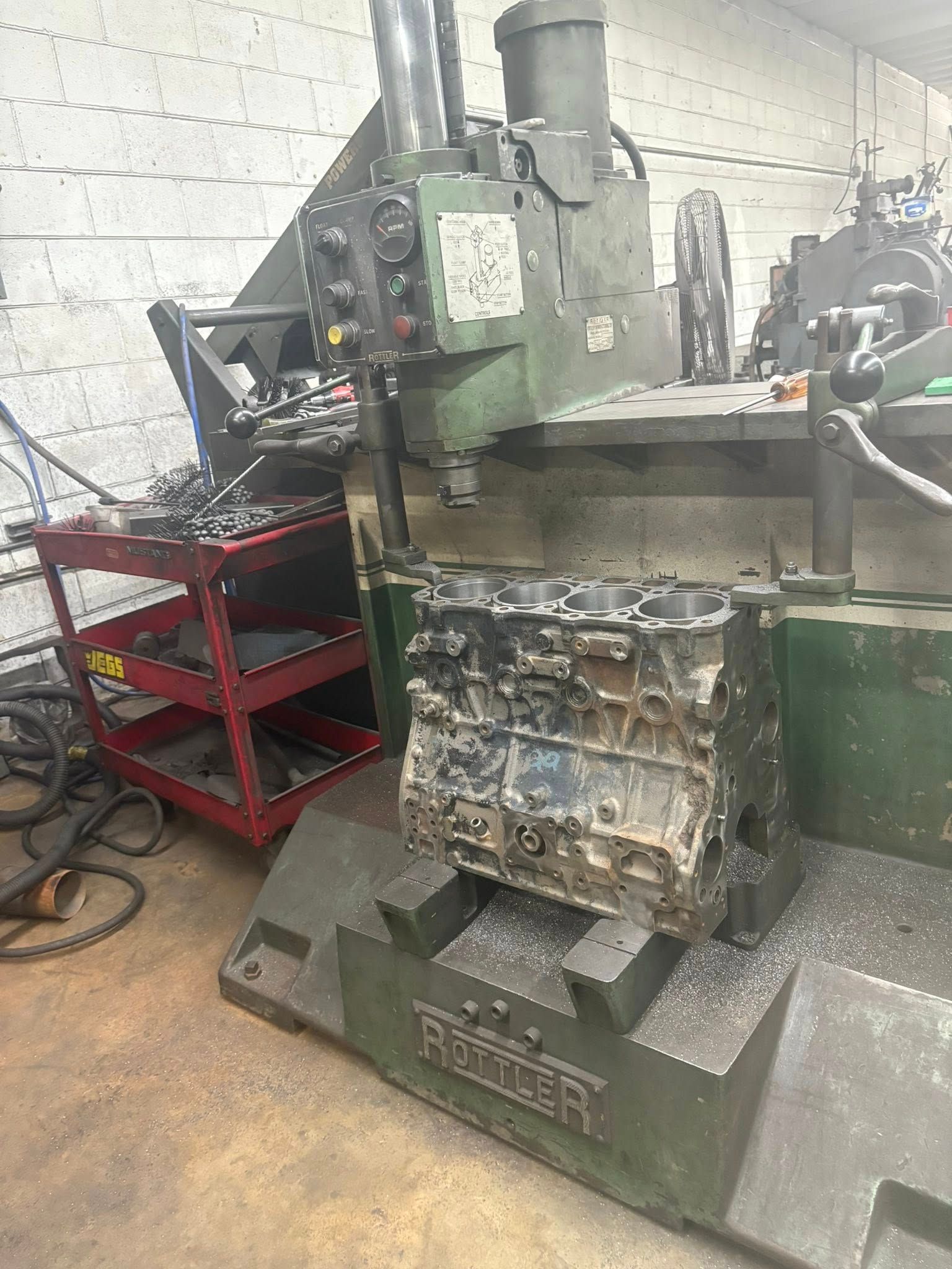 A machine is cutting a piece of metal in a garage.