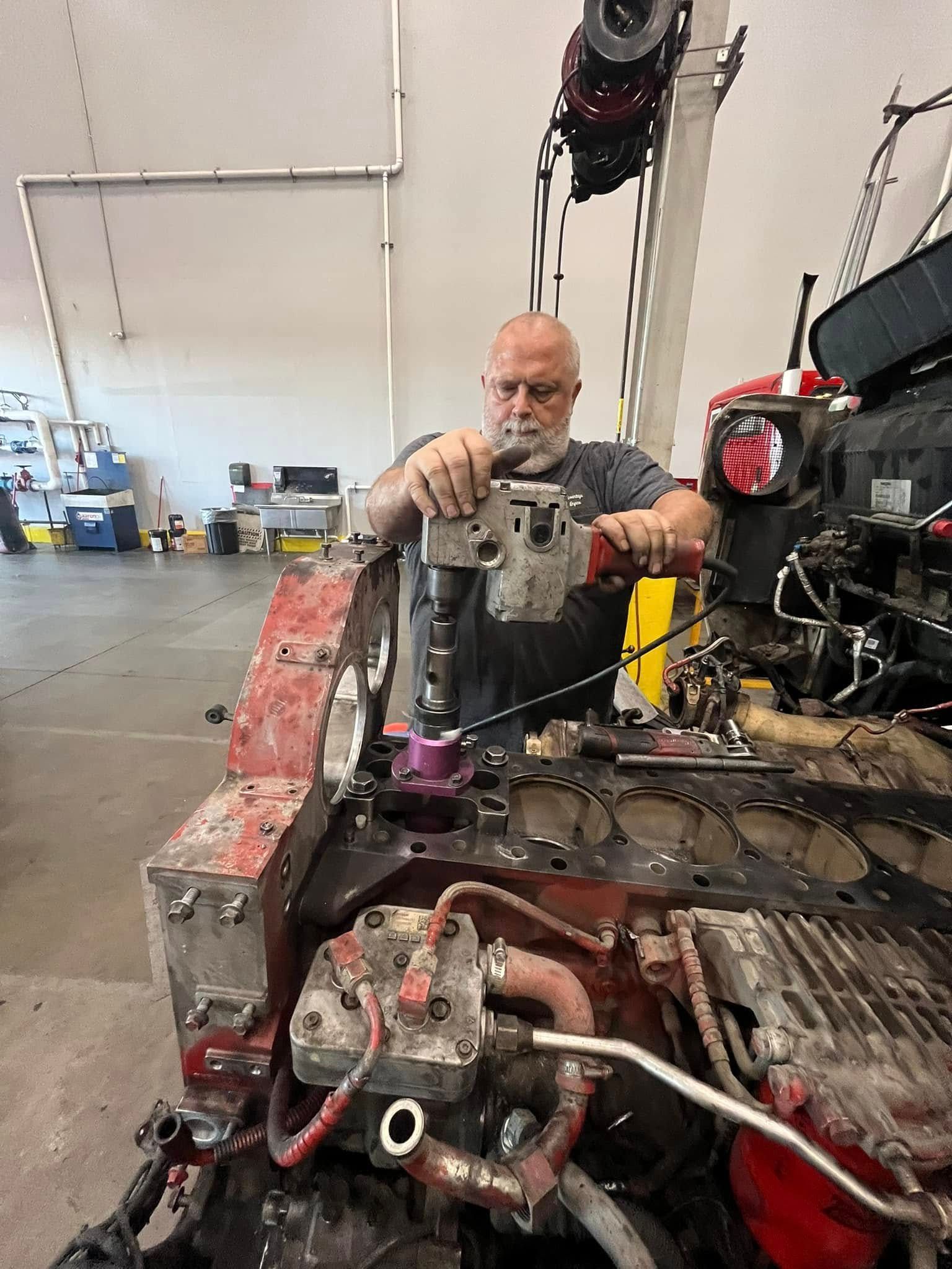 A man is working on a car engine in a garage.