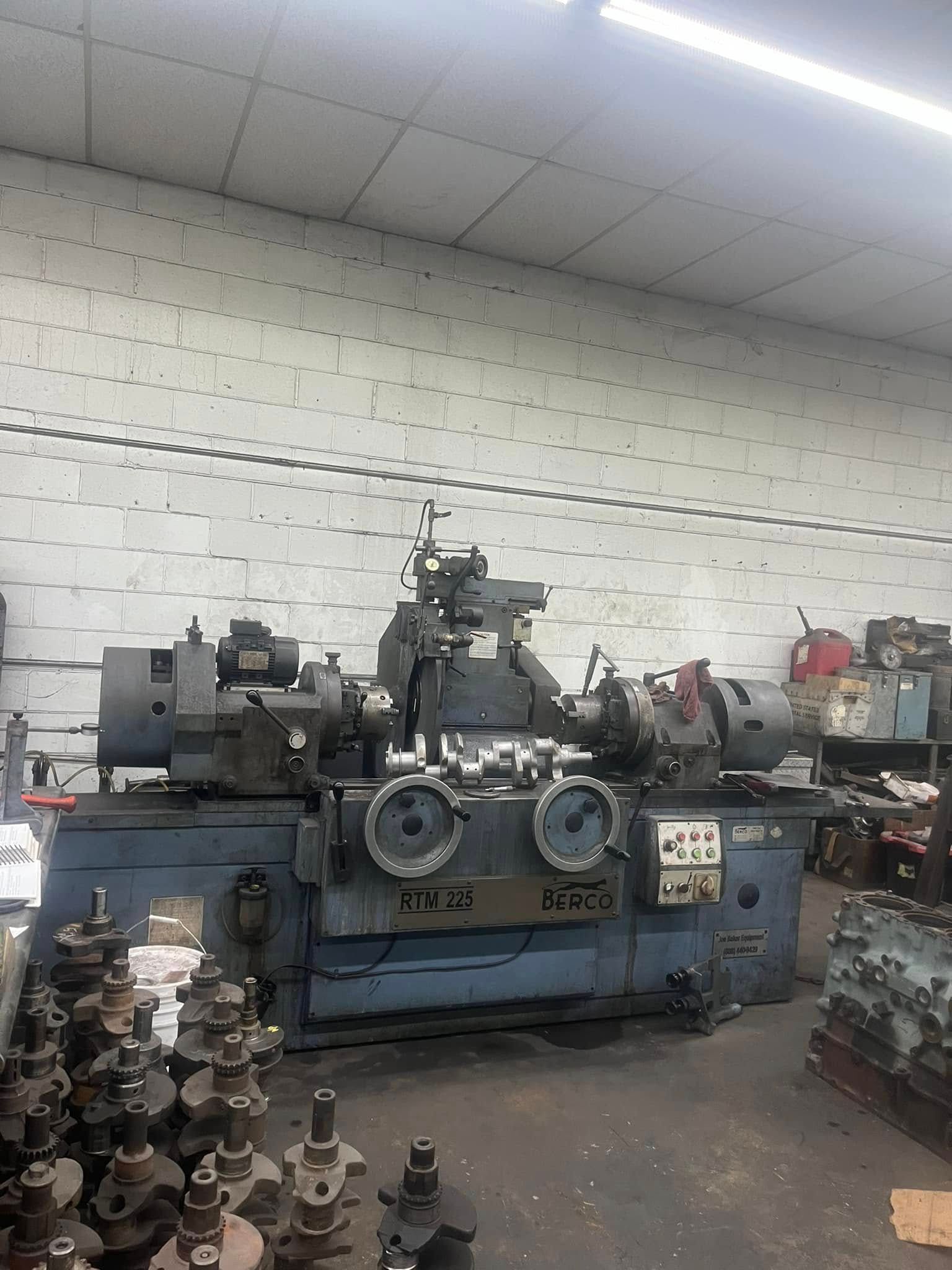 A machine is sitting in a warehouse next to a brick wall.