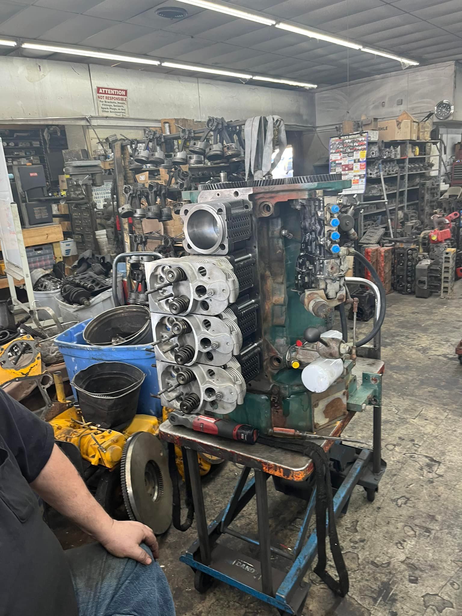A man is sitting in a garage working on a machine.