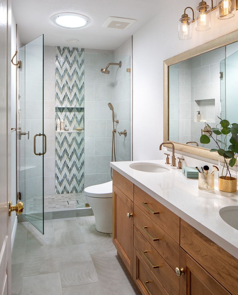 Modern bathroom with glass shower, double vanity, large mirror, and light wood cabinetry