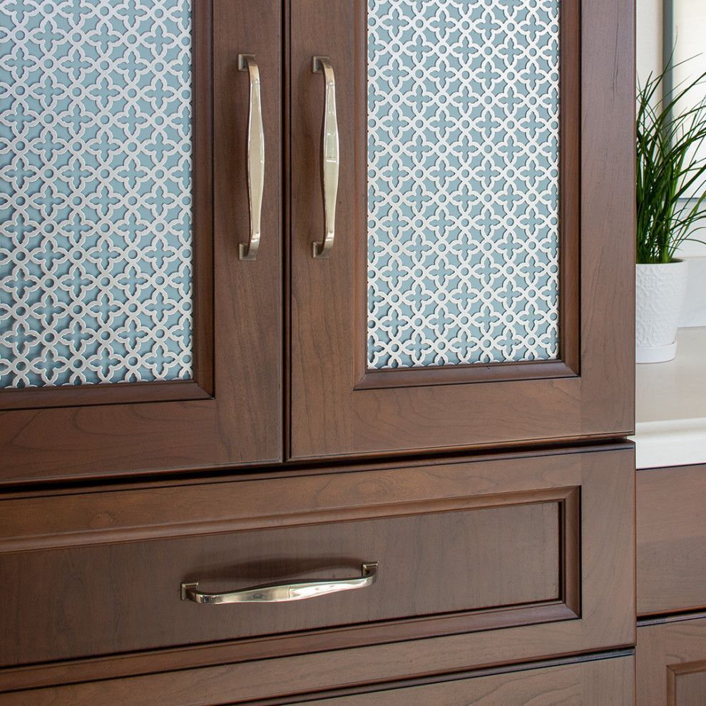 Brown wooden cabinet with patterned glass doors and a drawer
