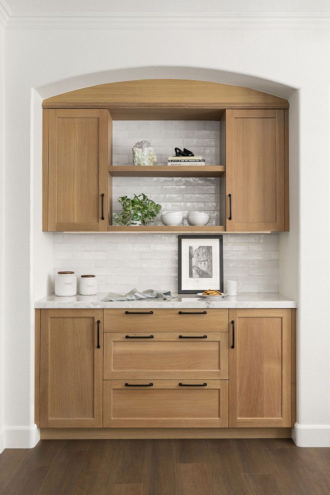 Built-in wooden kitchen hutch with open shelves, cabinets, drawers, and decor in a white alcove
