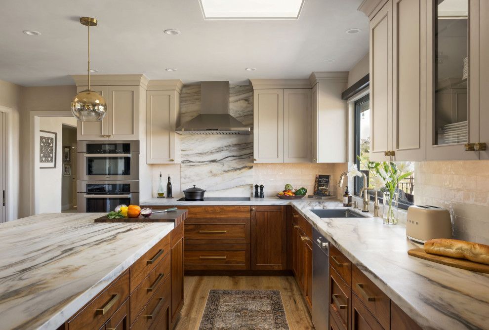 Modern kitchen with wood cabinets, marble countertops, stainless appliances, and a large island
