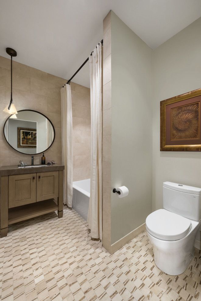 Modern bathroom with vanity, round mirror, shower, and toilet in beige and wood tones