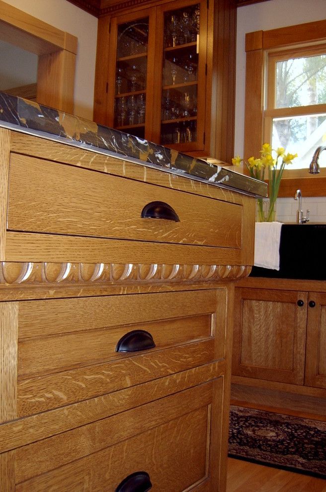 Wooden kitchen cabinets and drawers beside a window with yellow flowers