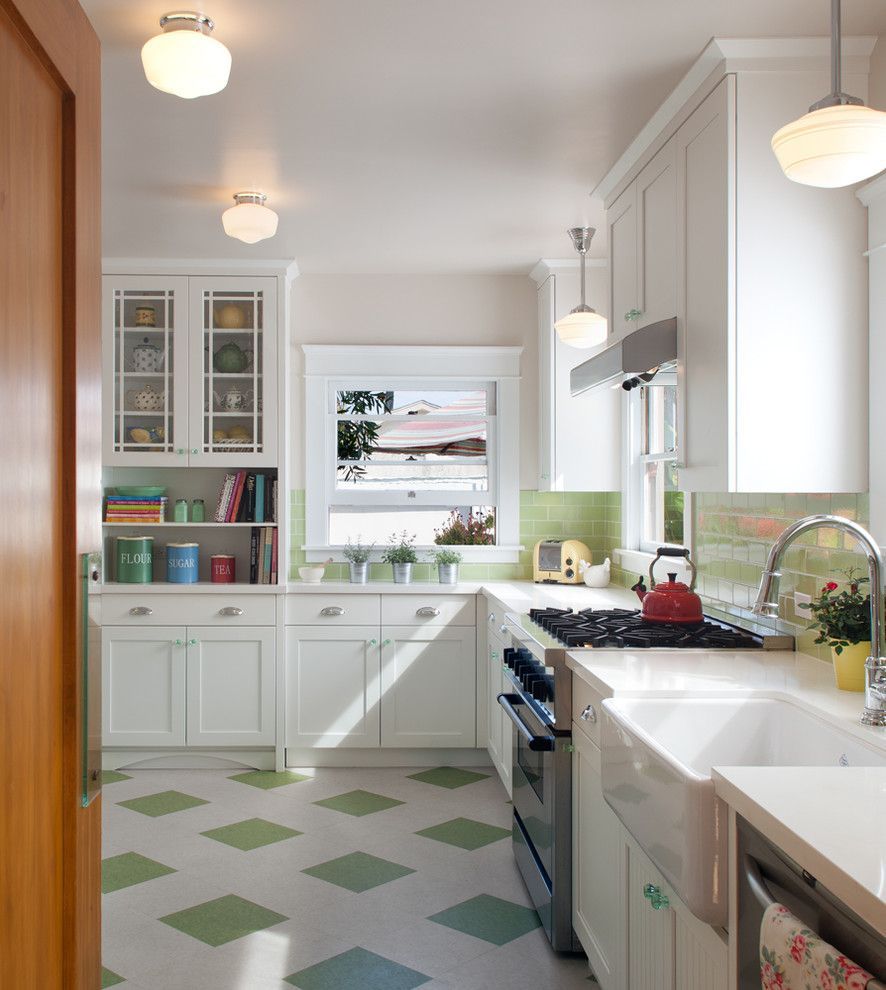 Bright white kitchen with green accents, patterned floor, and sunlight through the window