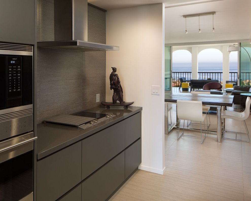 Modern kitchen with dark cabinets opens to a bright dining area and balcony view