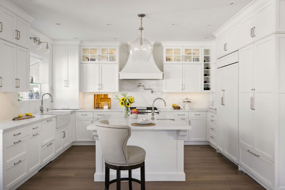 Green kitchen with white countertops, sink, and checkered floor leads to a dining area.