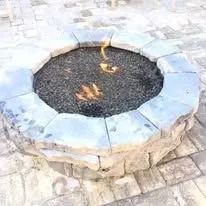 Fire pit made of stone with a fire burning inside.