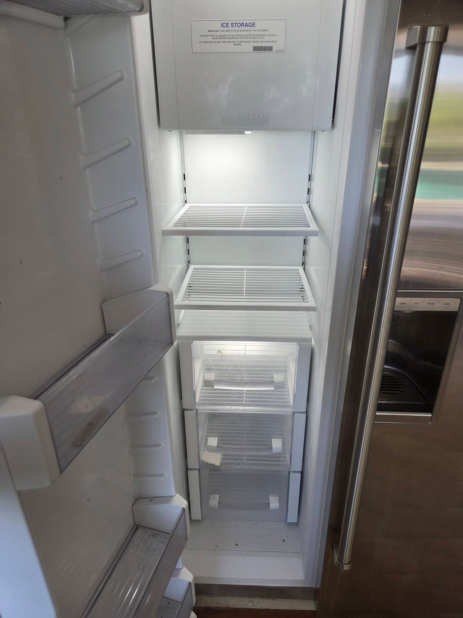 Open refrigerator with shelves, clear drawers, and freezer compartment visible inside.