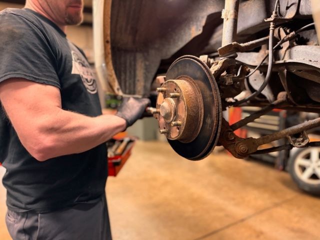 A man is working on a car in a garage.