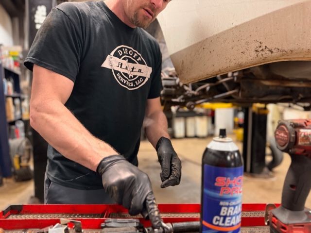 A man in a black shirt is working on a car