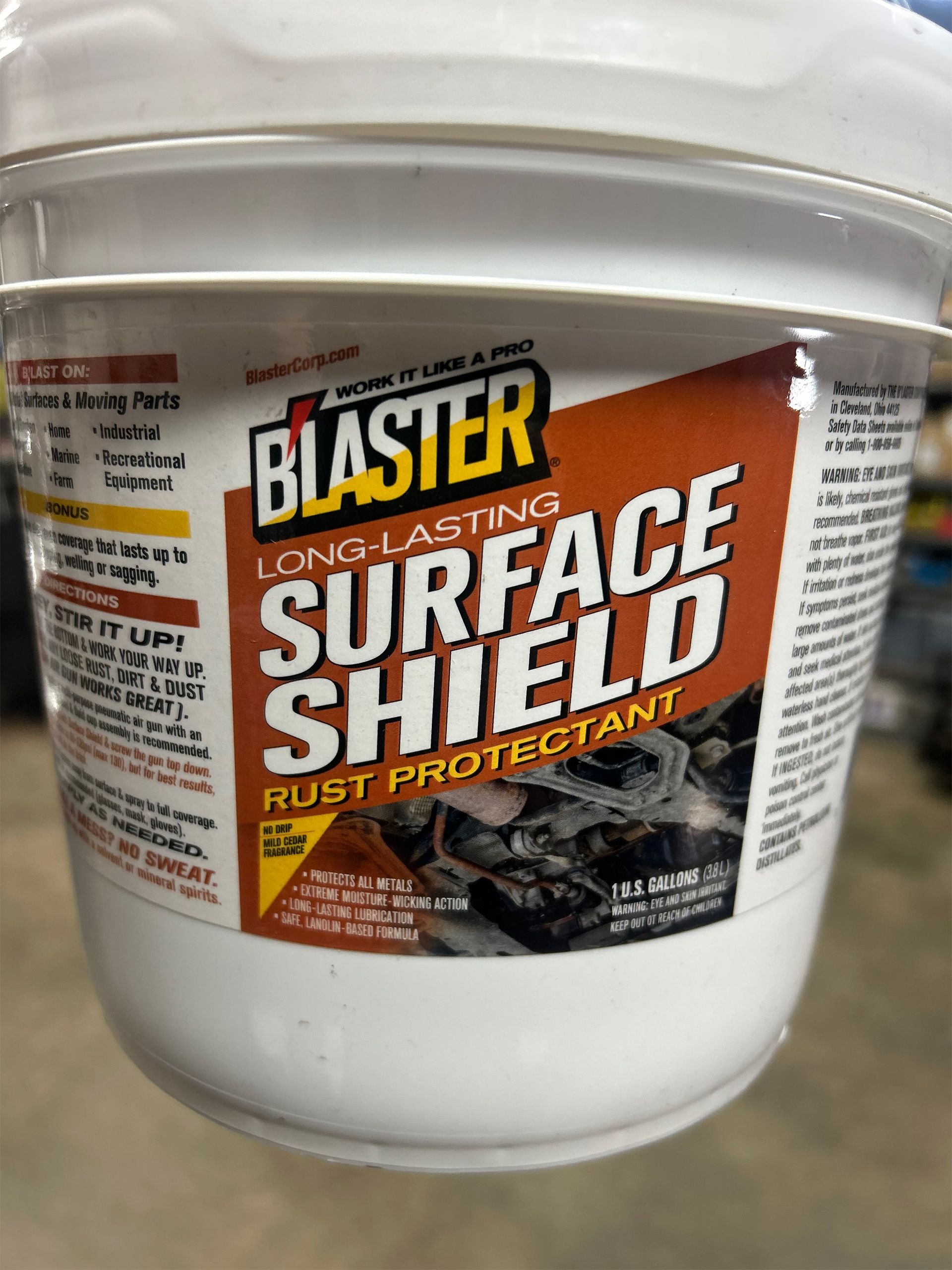 A bucket of blaster surface shield rust protectant is sitting on a table.