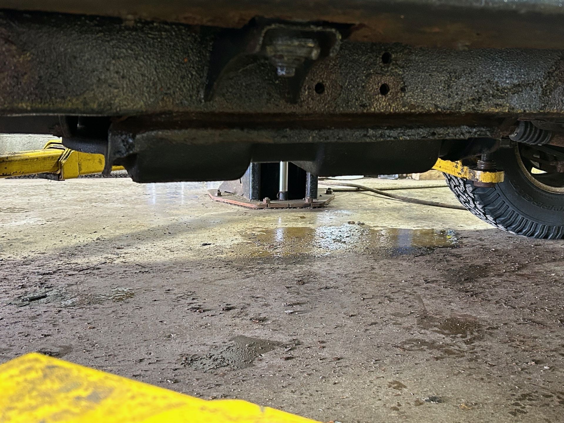A car is sitting on a lift in a garage.