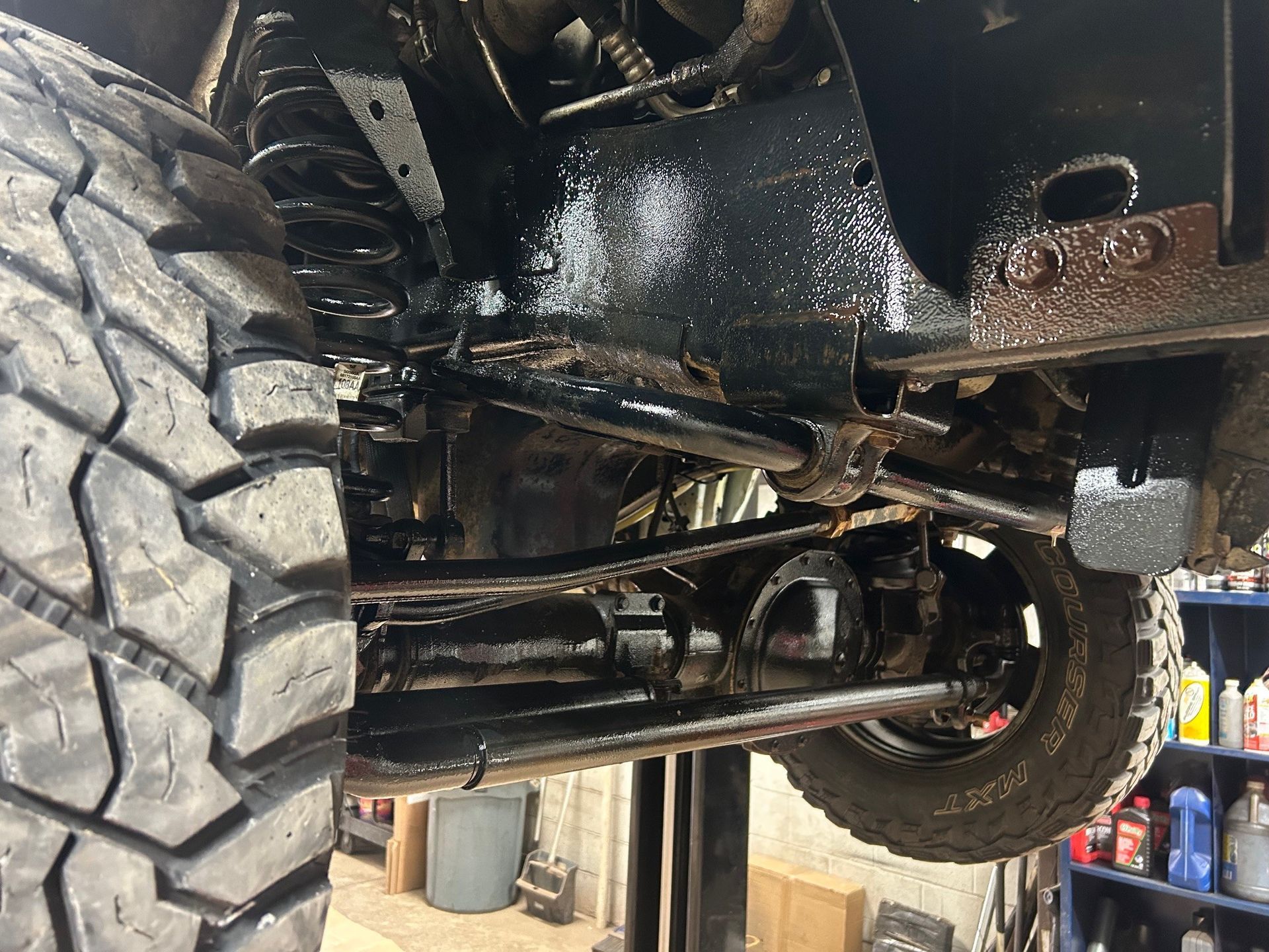 A truck is sitting on a lift in a garage.