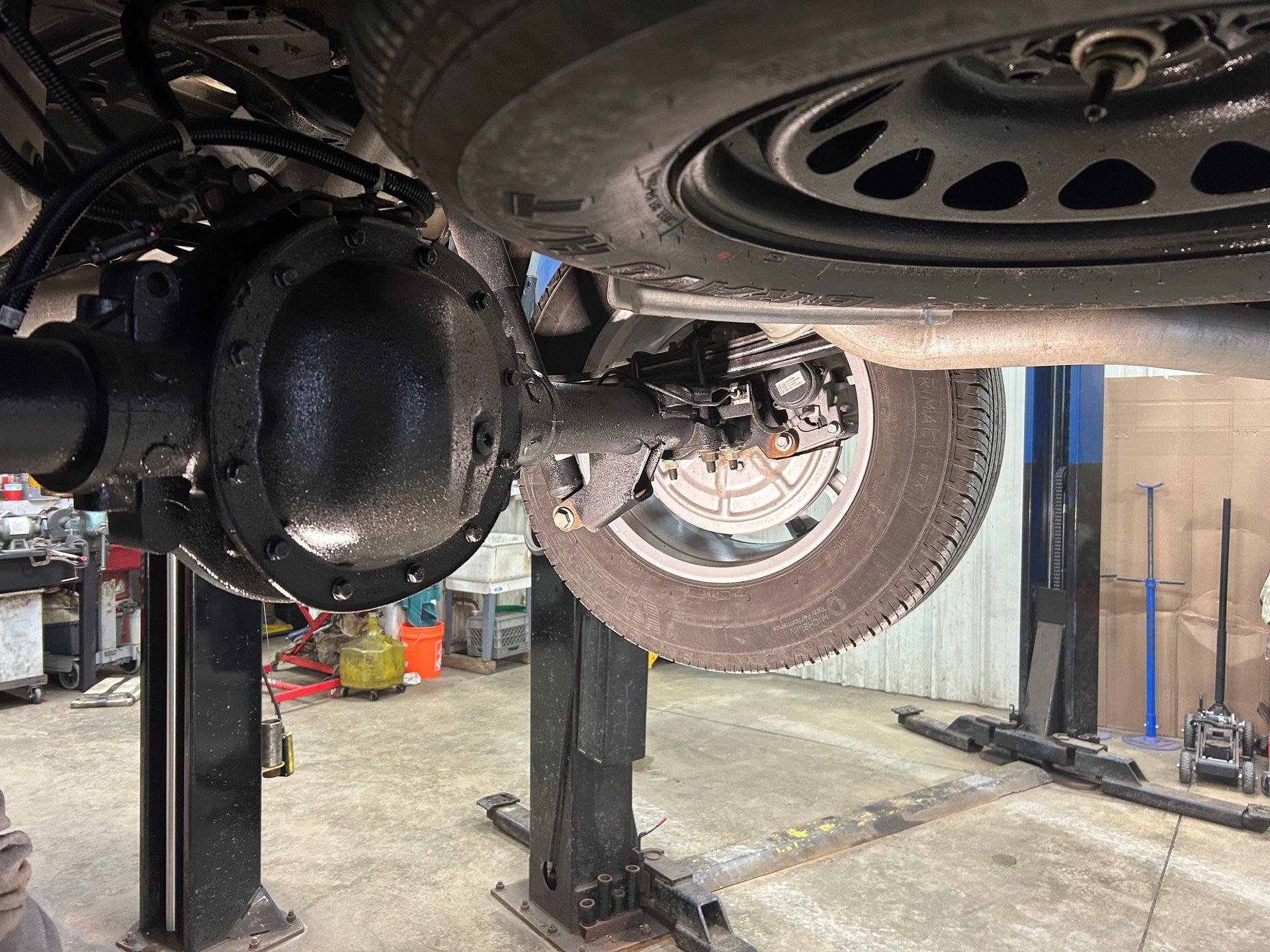 A car is sitting on a lift in a garage.