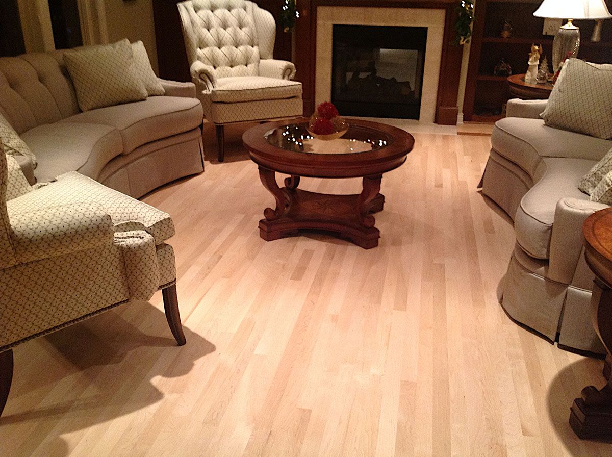 Living room with hardwood floors, upholstered furniture, coffee table, and fireplace