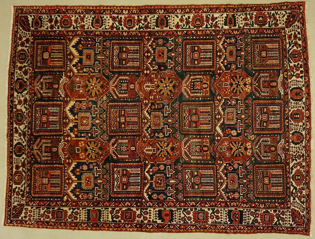 Red and brown geometric patterned rug with a cream border