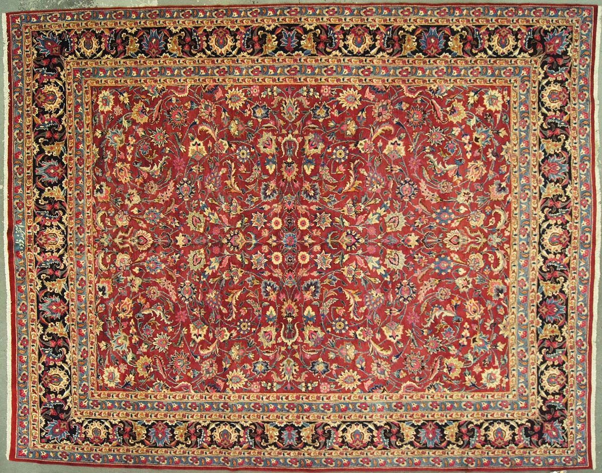 Red Oriental rug with floral and geometric patterns, framed by a dark border