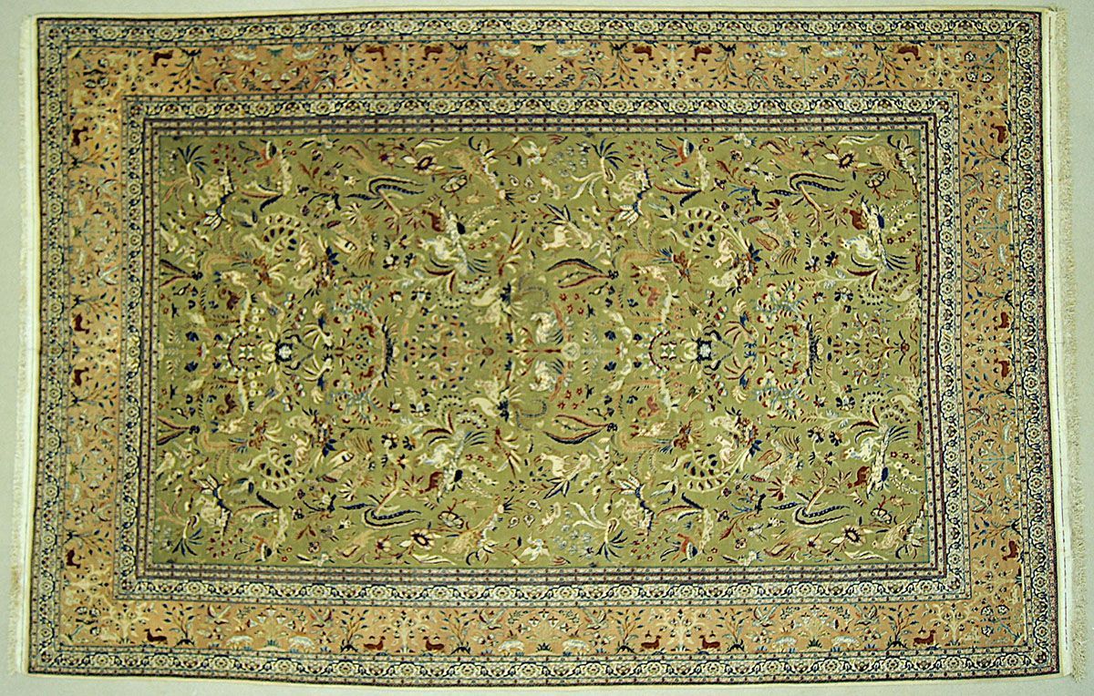 Green and tan rectangular rug with floral and geometric patterns
