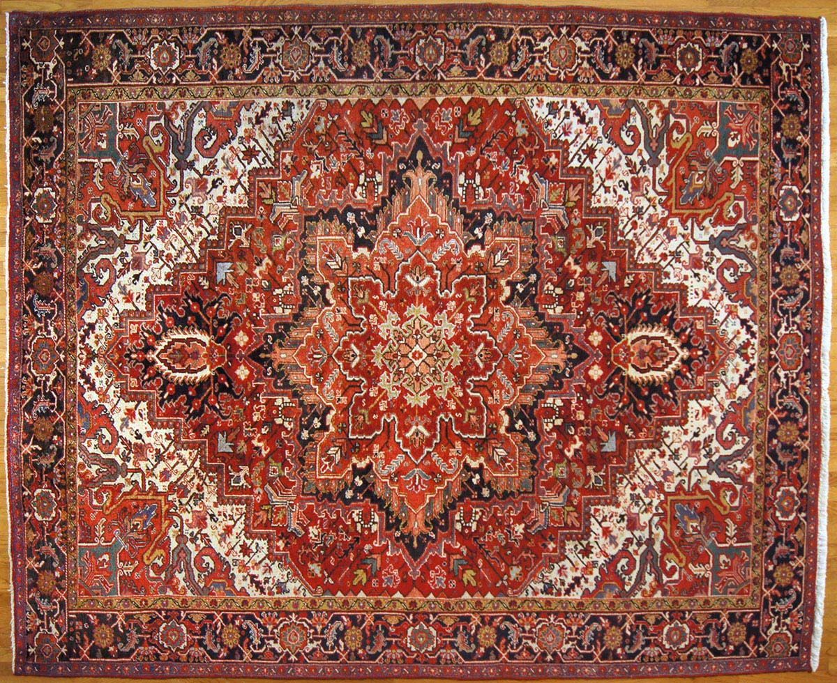 Red and white ornate Oriental rug with central medallion pattern on wood floor