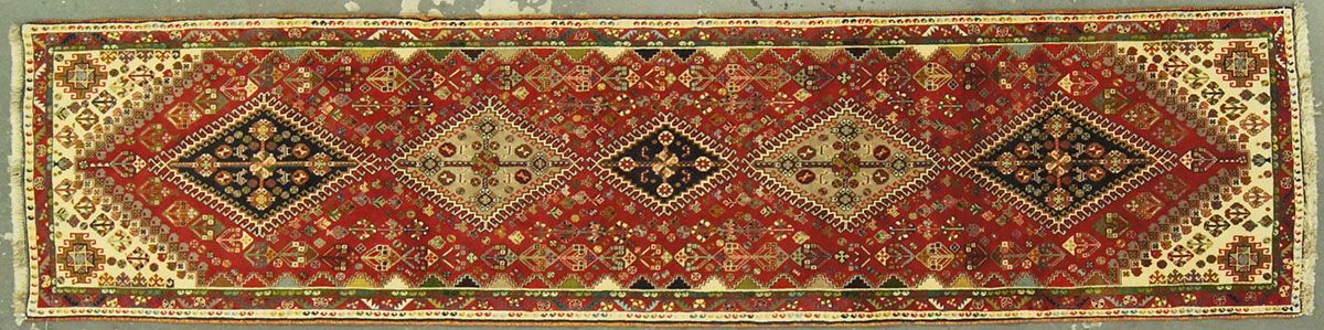 Rectangular red carpet with cream and black diamond patterns