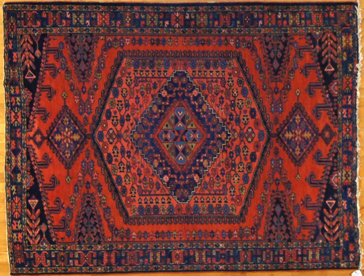 Red and blue patterned Oriental rug on wooden floor