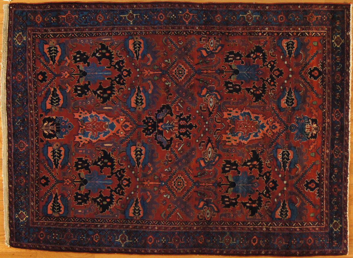 Red and blue patterned Oriental rug on wood floor