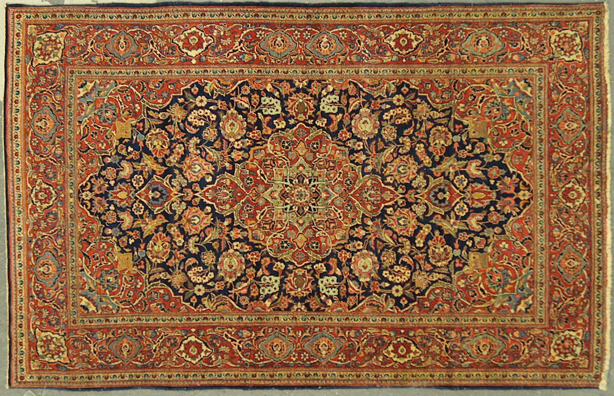 Intricately patterned Persian rug, dark blue center with floral design, red border and background