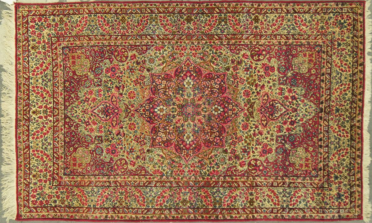 Red and gold patterned Oriental rug with fringed edges